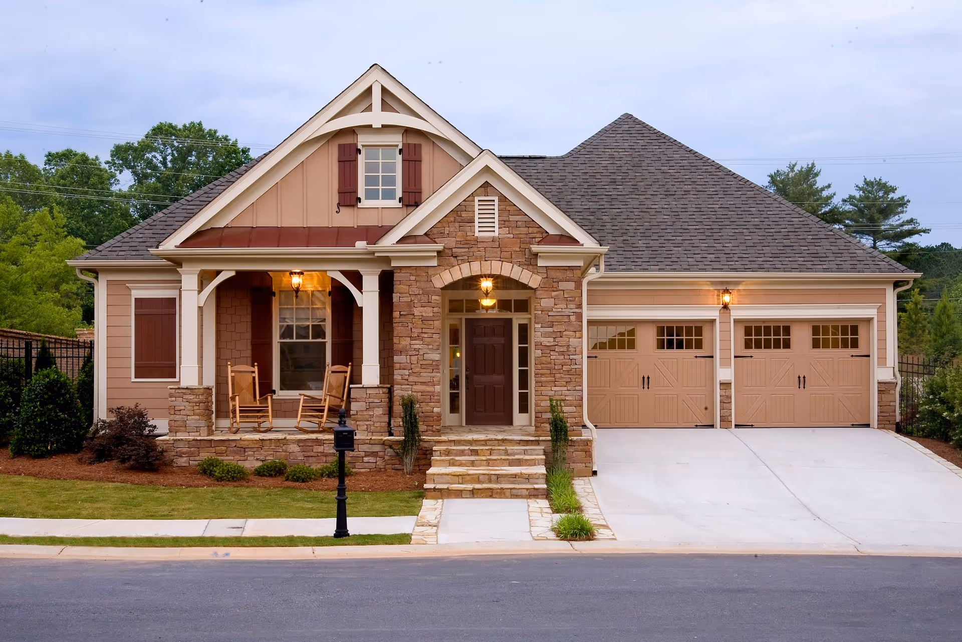 A stone-and-siding senior living facility exterior with a welcoming front porch and two-car garage.