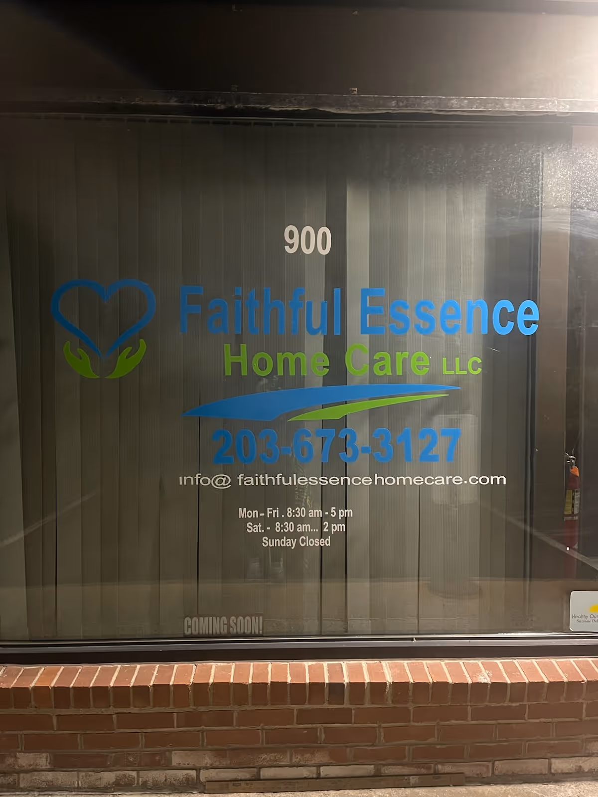 Front view of Faithful Essence Home Care signage on glass storefront with blue logo