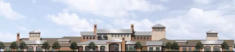 Front exterior view of a large senior living facility building with multiple towers, brick and stone facade, and a covered entrance. The building is surrounded by landscaped greenery and a clear blue sky with some clouds.
