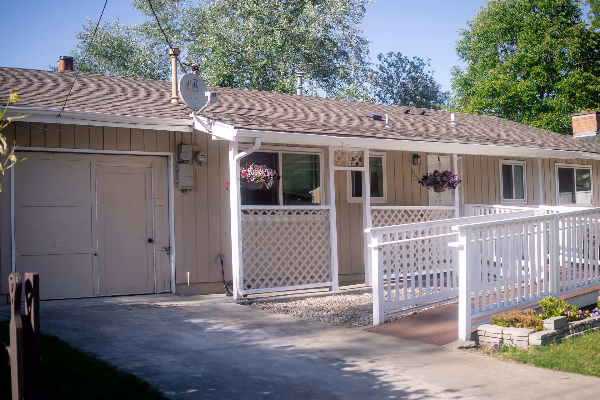 Front view of Adel Home Care LLC facility with white porch railing and hanging baskets.