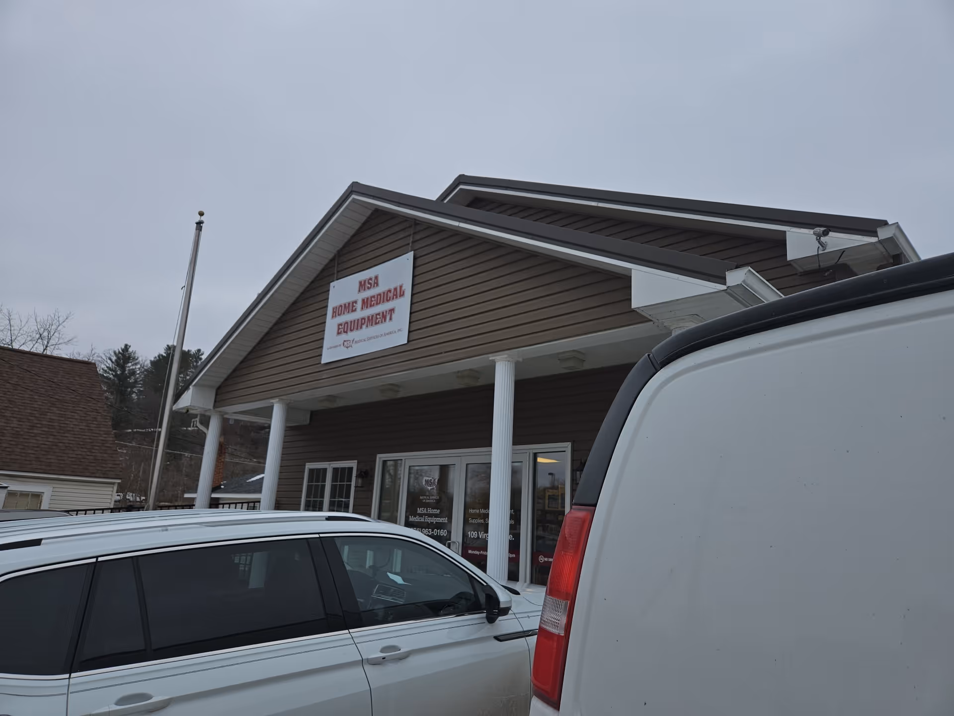 Front view of a brown building with MSA Home Medical Equipment sign and parked cars.