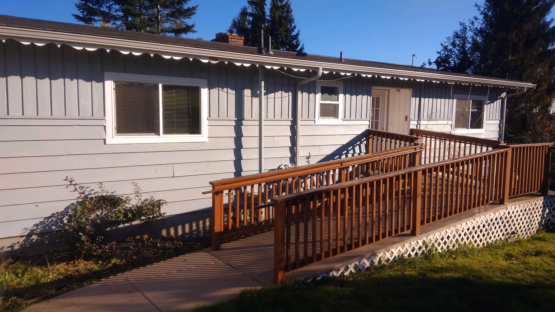 Single-story gray facility exterior with a wooden ramp to the front entrance.