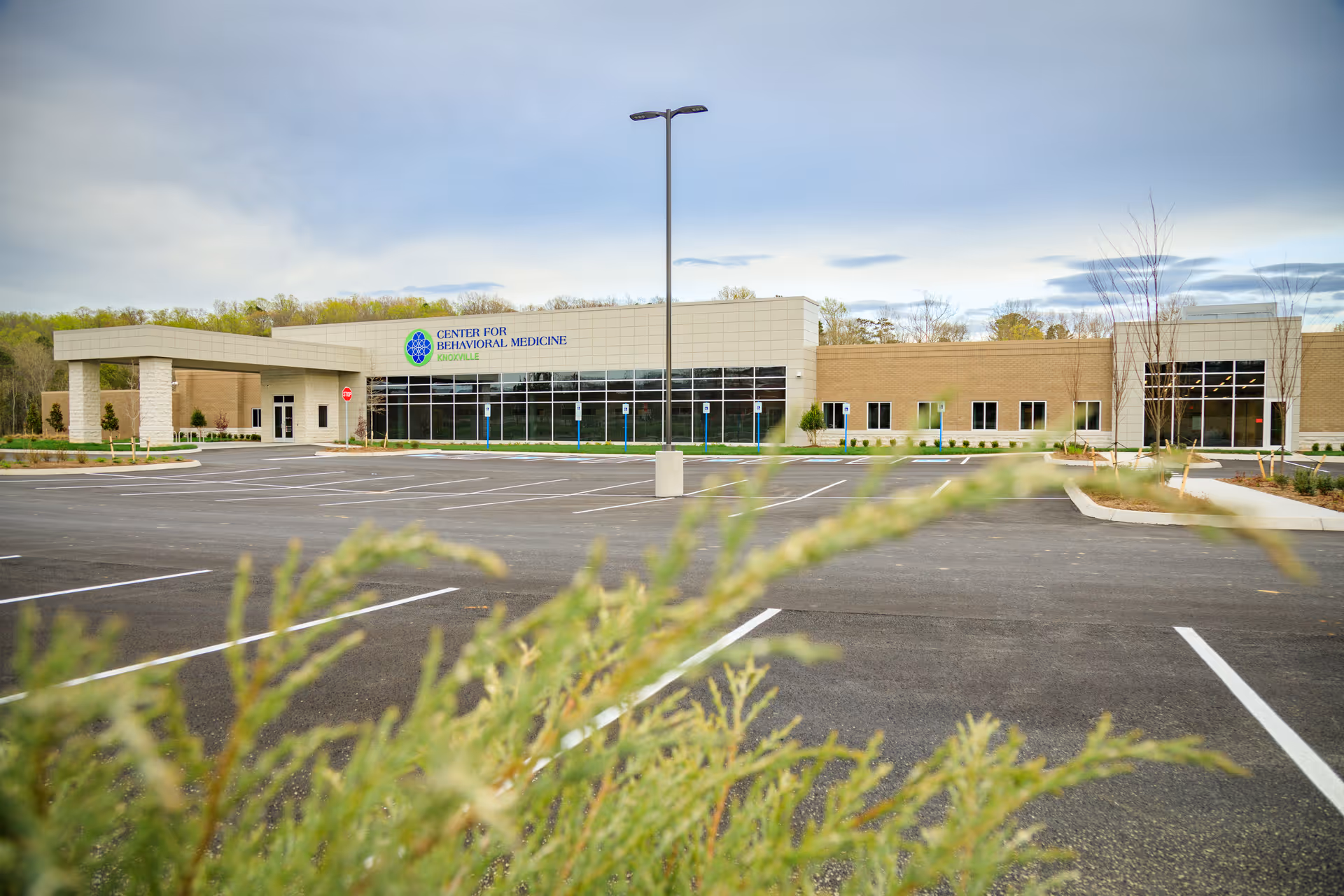 Exterior view of Knoxville Center for Behavioral Medicine with a large parking lot and landscaping.