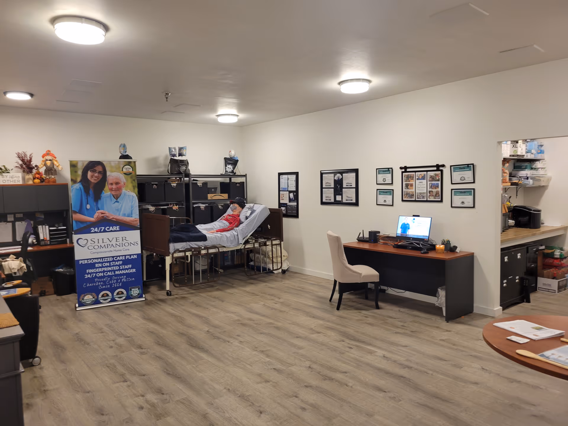 Interior view of Silver Companions facility with a patient bed, desk, and framed certificates.