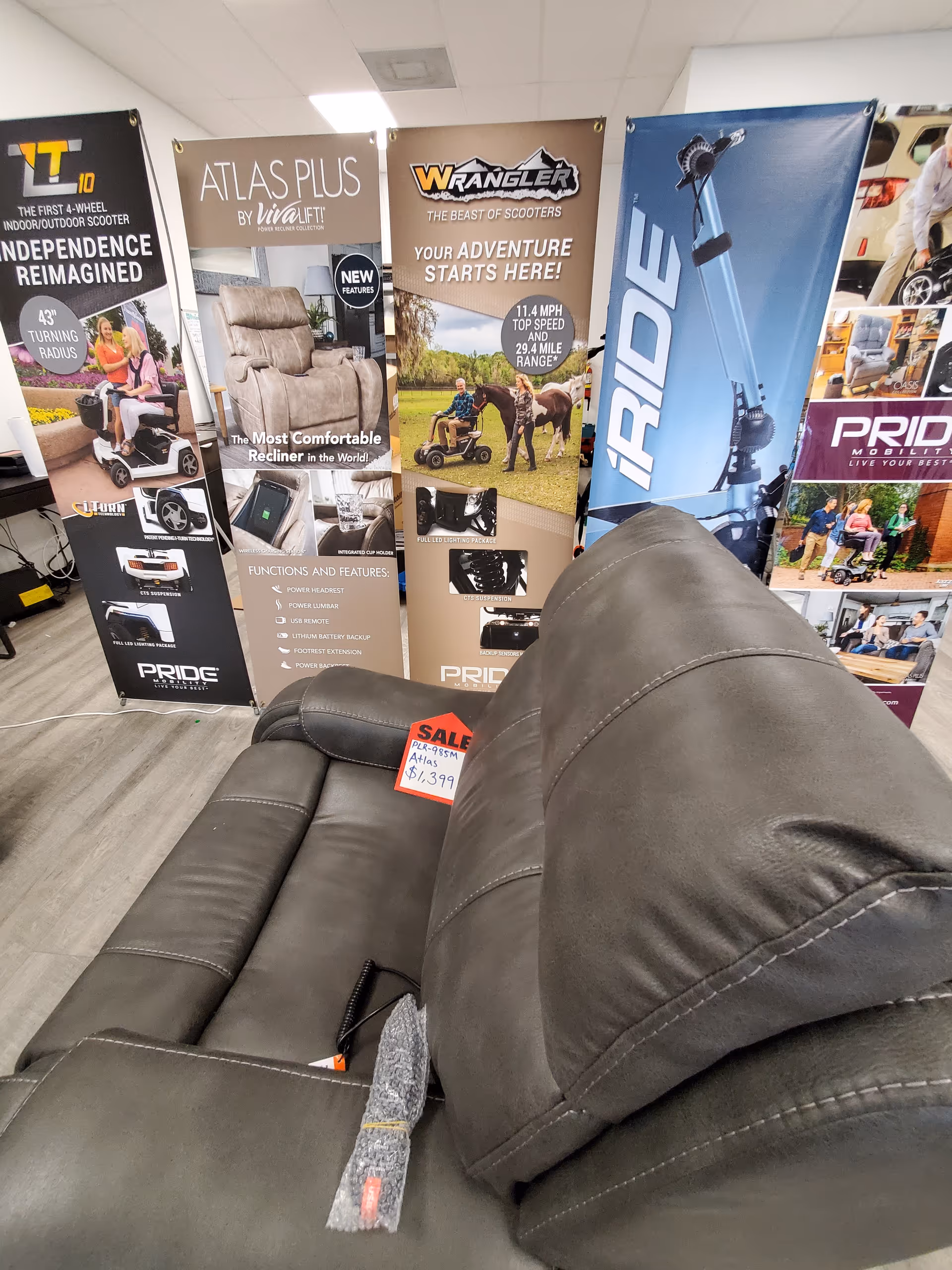 Indoor showroom at Statewide Mobility with leather sofa and scooter banners.