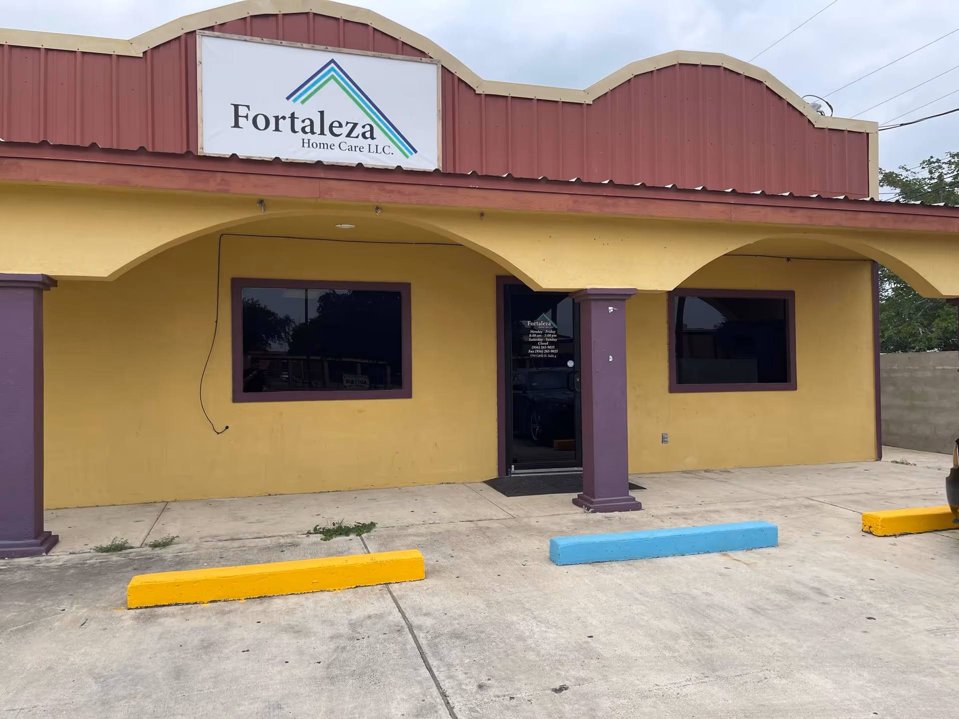 Front exterior of Fortaleza Home Care LLC building with yellow walls and purple trim.
