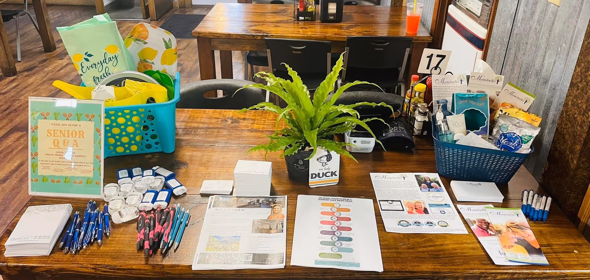 Reception desk with brochures, pens, a plant, and baskets in a senior living lobby.