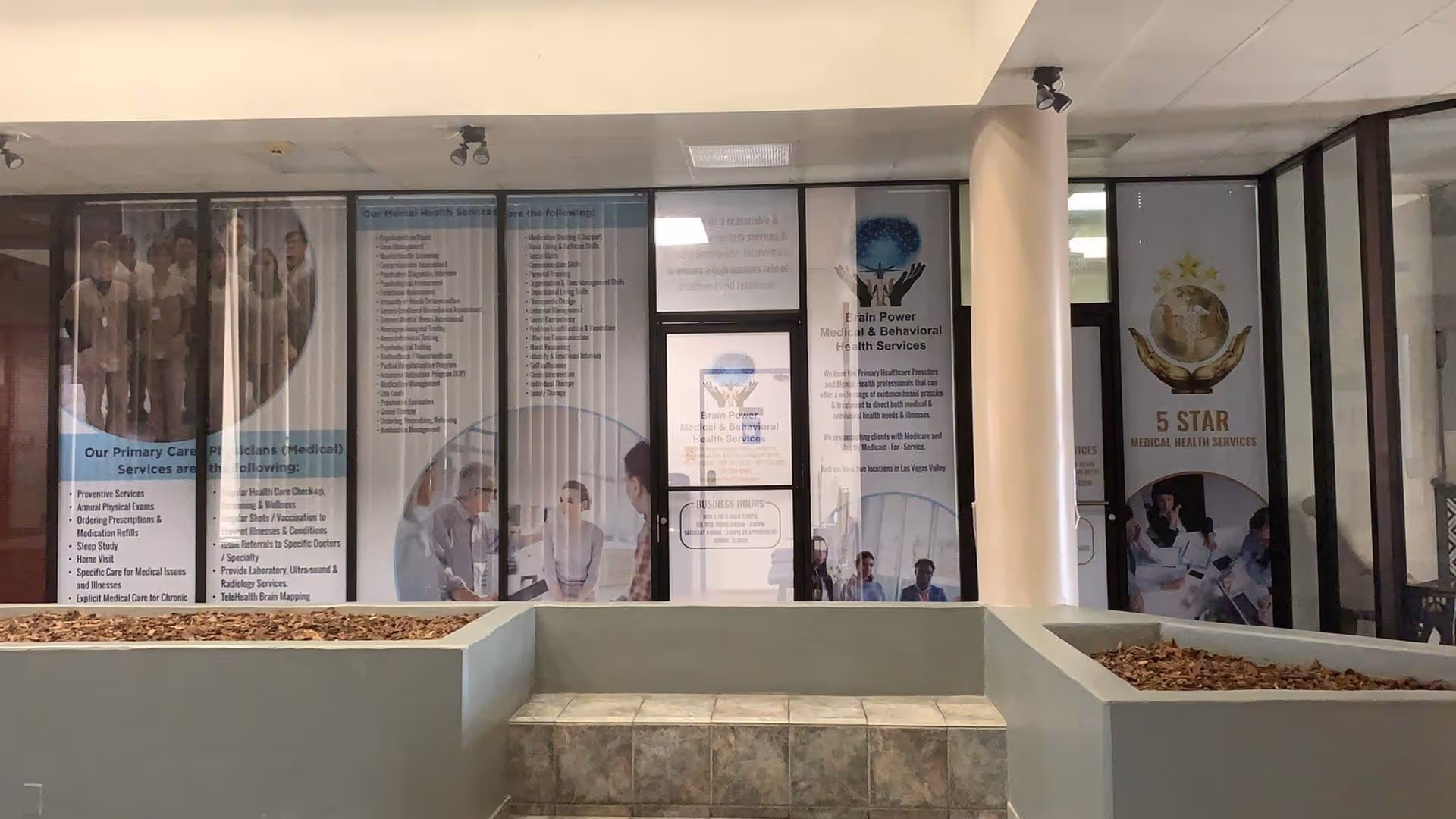 Lobby area of Brain Power Medical Center with glass walls and promotional posters.