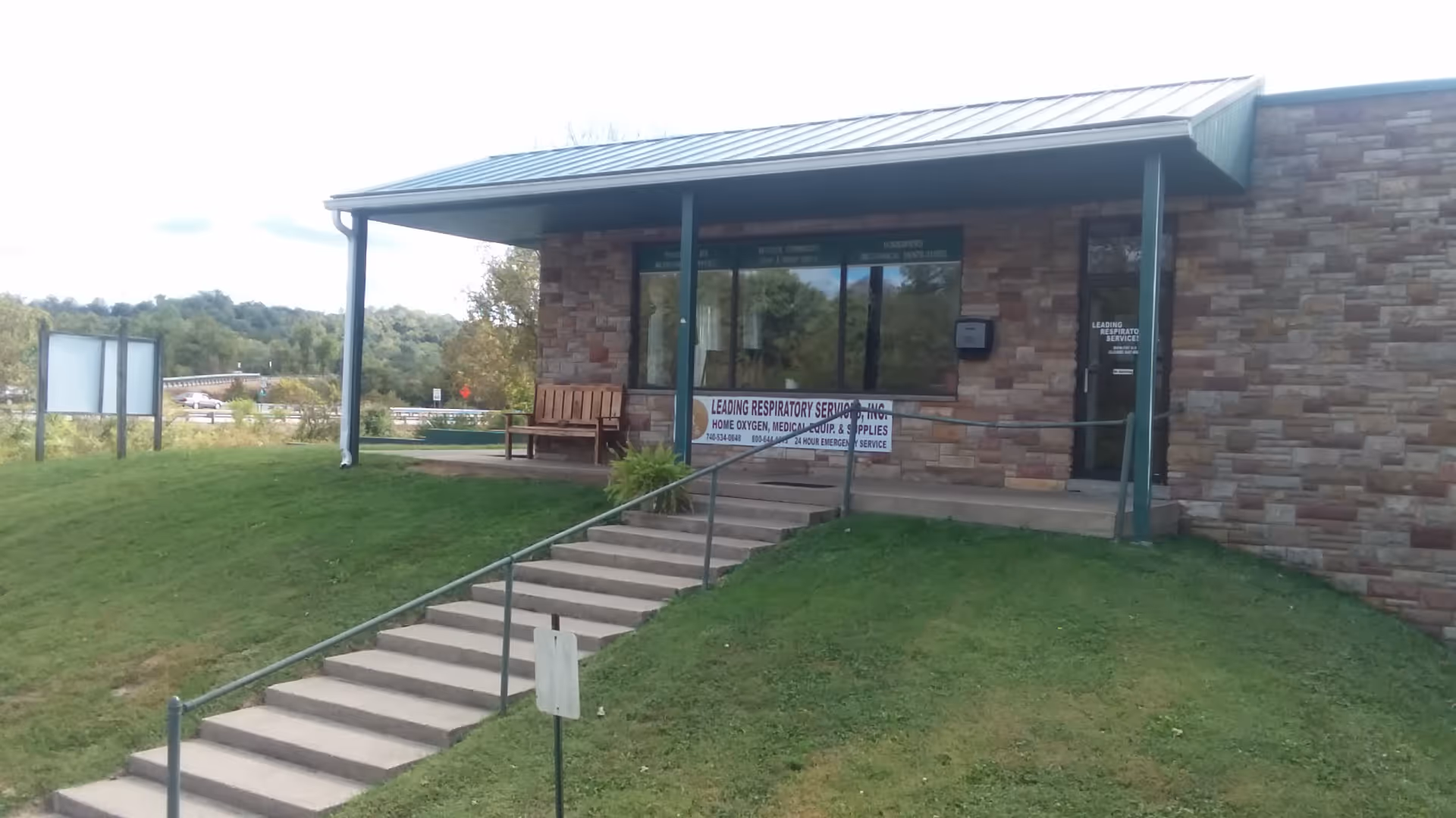 Exterior view of a brick facility with a ramp and Leading Respiratory Services signage.
