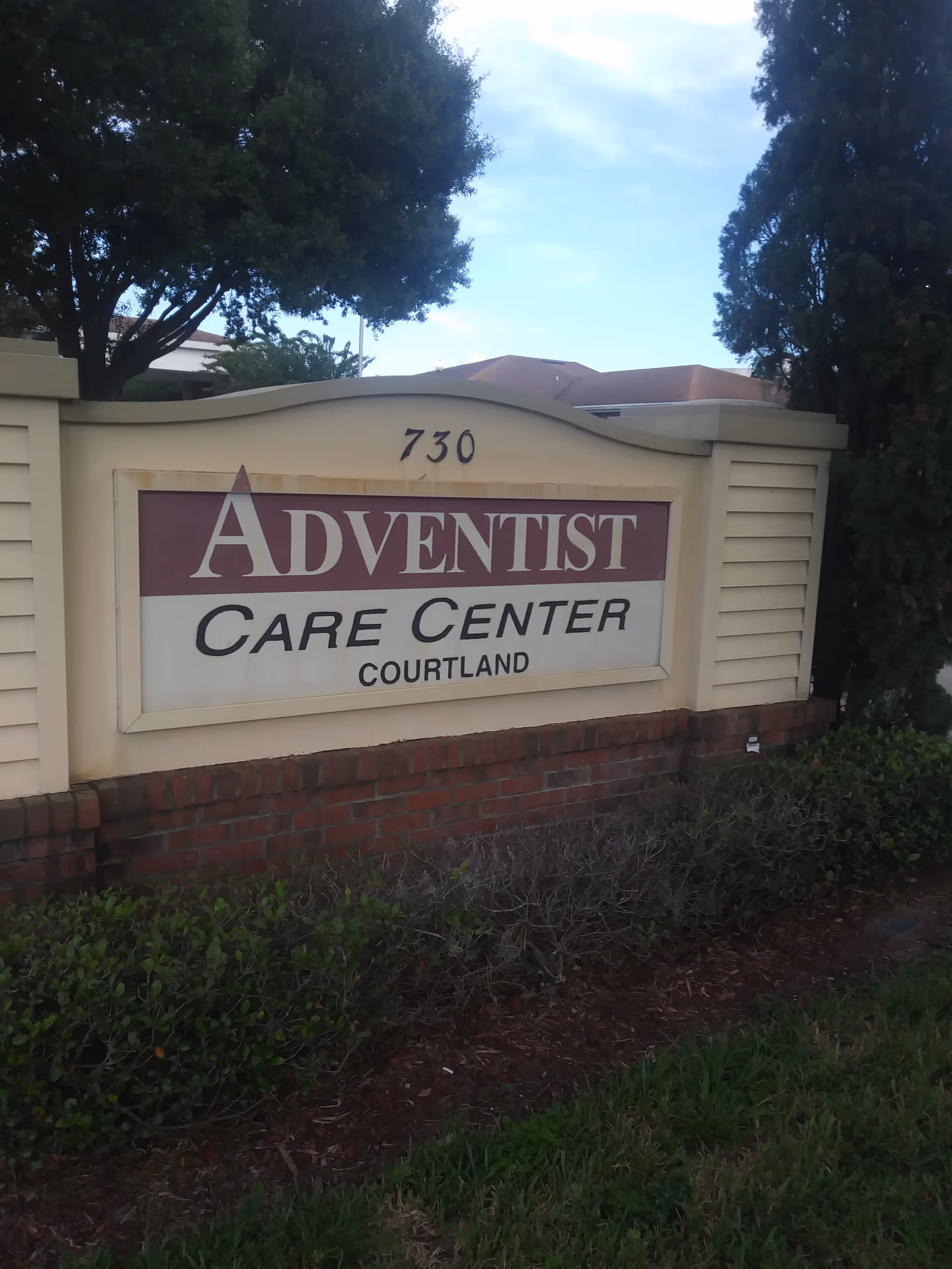 Exterior sign for Adventist Care Center Courtland with surrounding shrubs