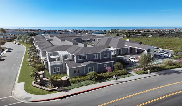 Exterior view of The Seville of San Clemente senior living campus near the coast.
