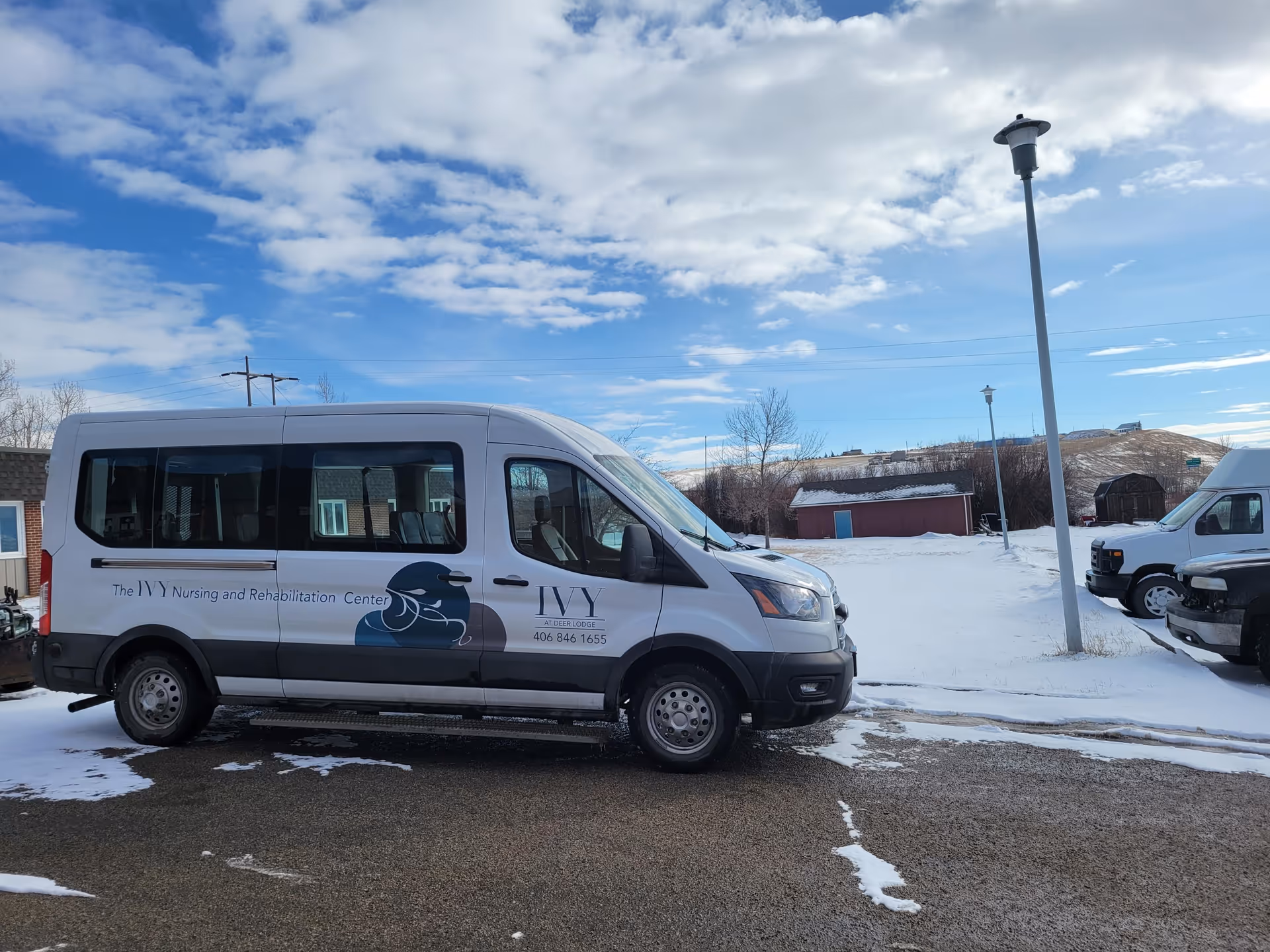 White van with Ivy Nursing and Rehabilitation Center logo parked on snowy lot.
