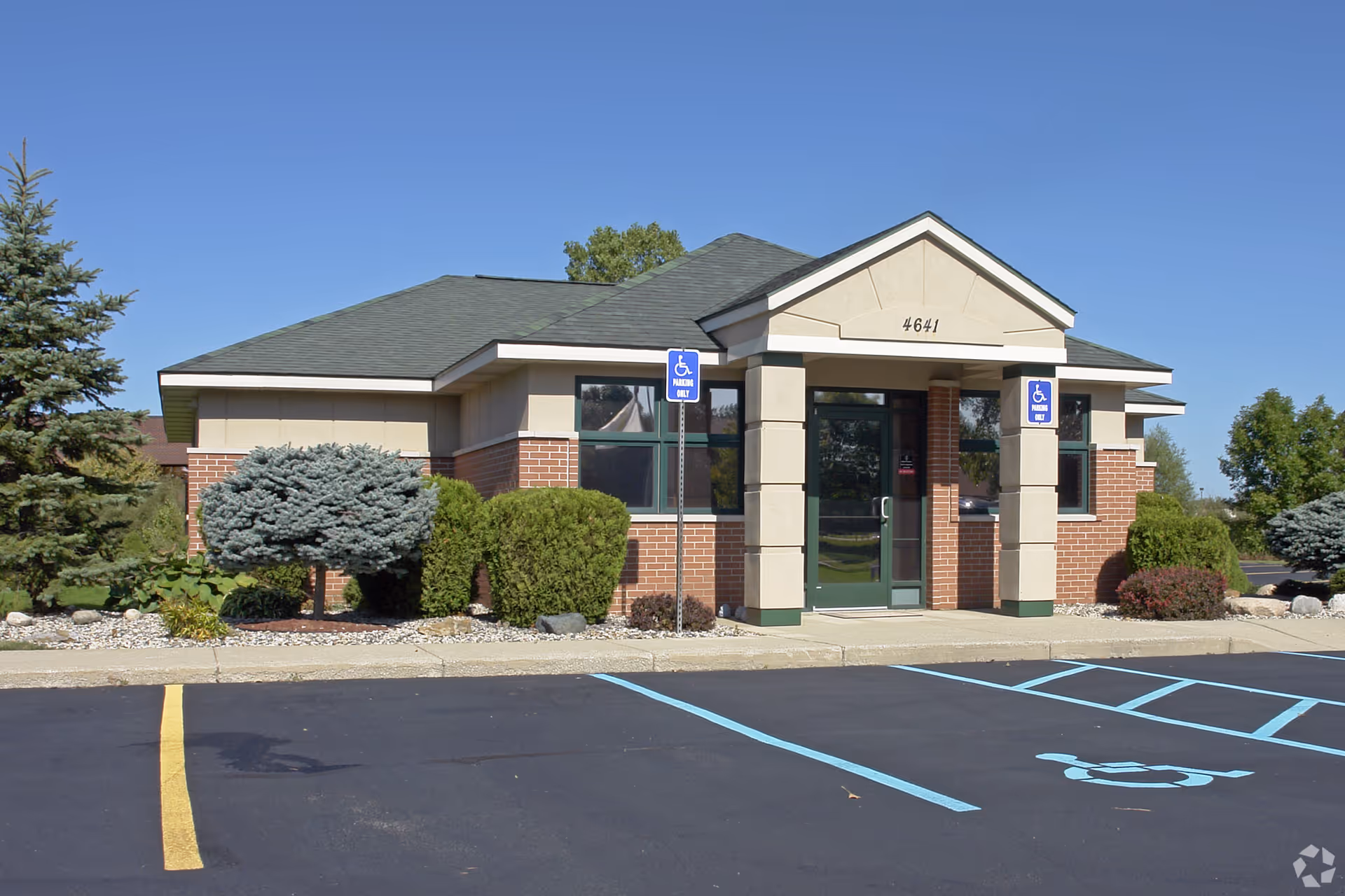 Single-story senior living facility front entrance with handicap parking and landscaping.