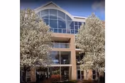 Front exterior of a brick senior living building with large arched windows.