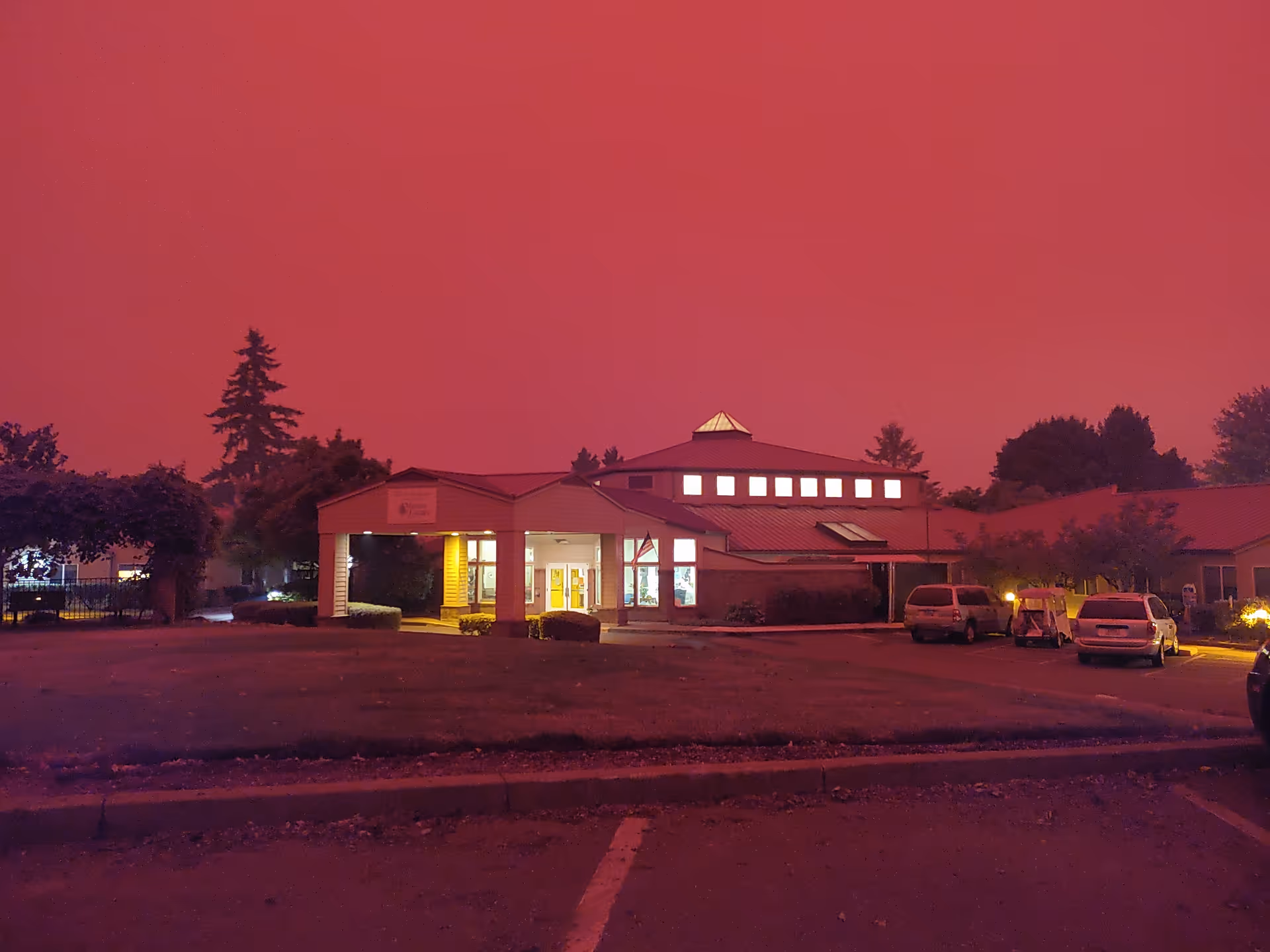 Nighttime exterior view of Elliott Residence building with parked cars.
