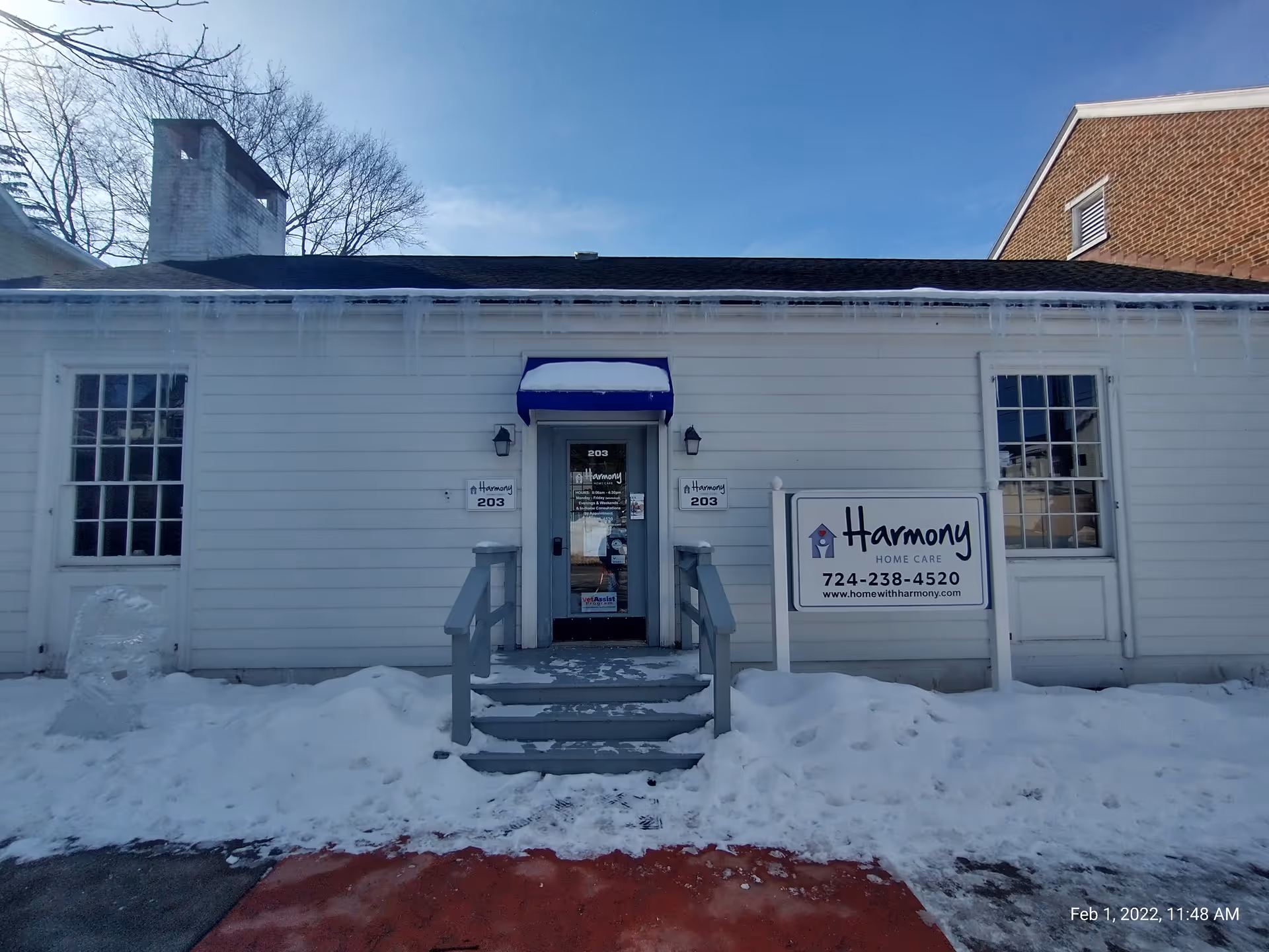 Exterior view of Harmony Home Care building with stairs and a snow-covered sign.