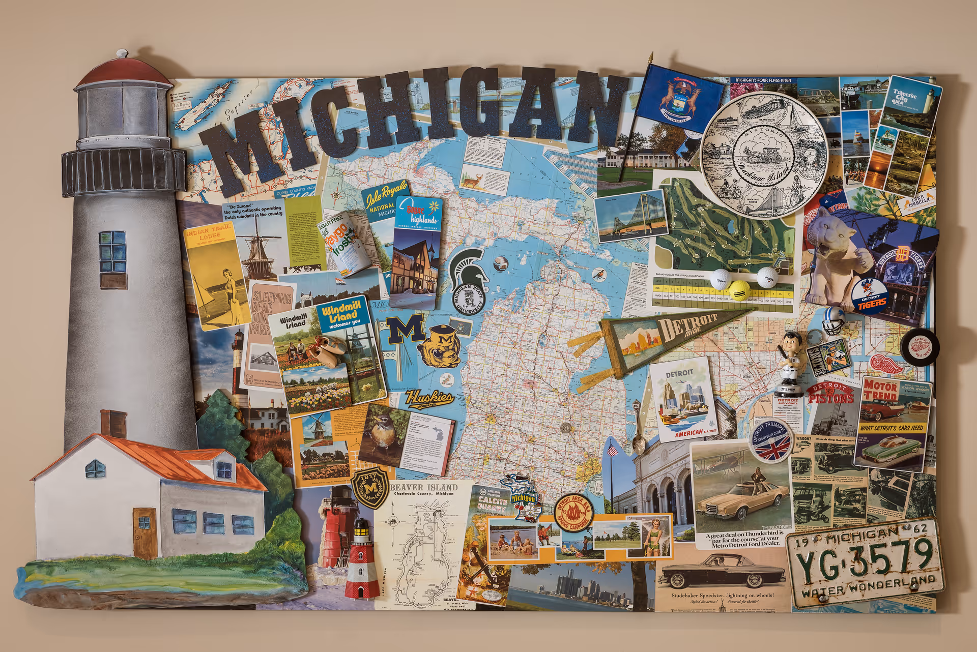 A decorative collage featuring a large map of Michigan with various postcards, photographs, and memorabilia related to Michigan. The collage includes images of lighthouses, sports logos, vintage postcards, a Detroit pennant, golf balls, and a Michigan license plate. The word 'MICHIGAN' is prominently displayed at the top in large letters.