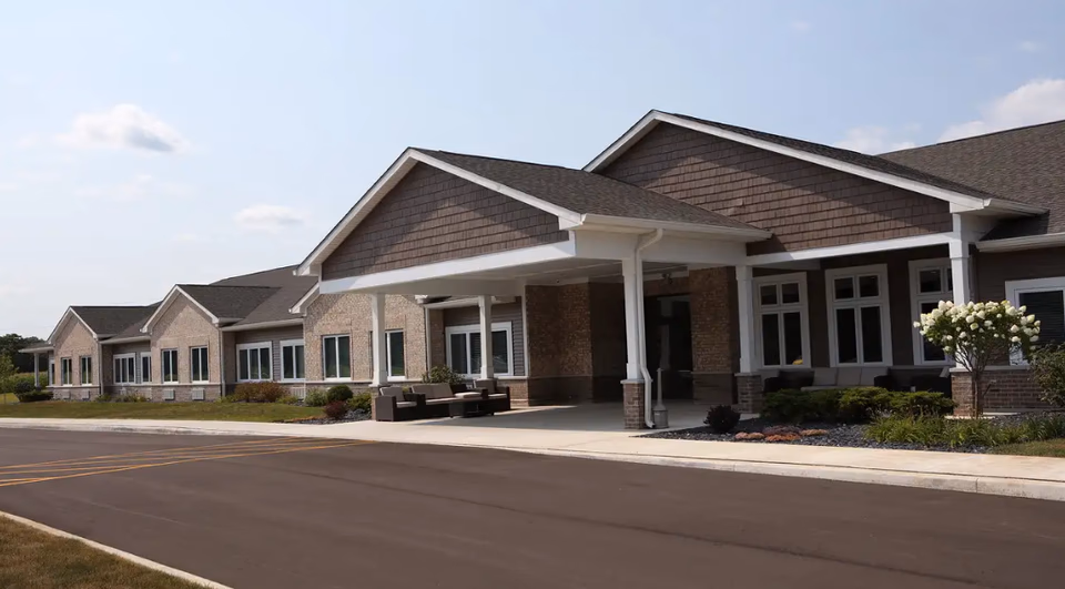 Wide view of a modern assisted living facility front with a covered entrance.
