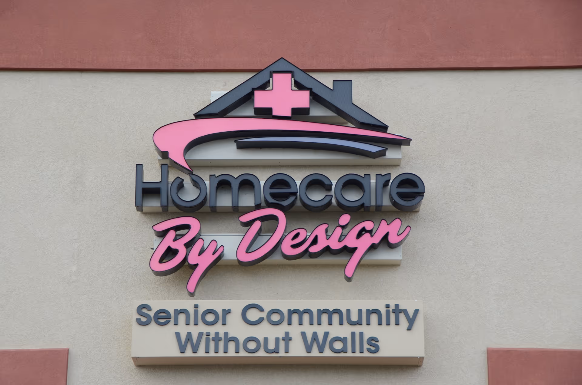 Exterior wall with a large Homecare By Design sign and Senior Community Without Walls.