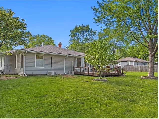 A single-story Comfort Living facility with a wooden deck and green lawn.