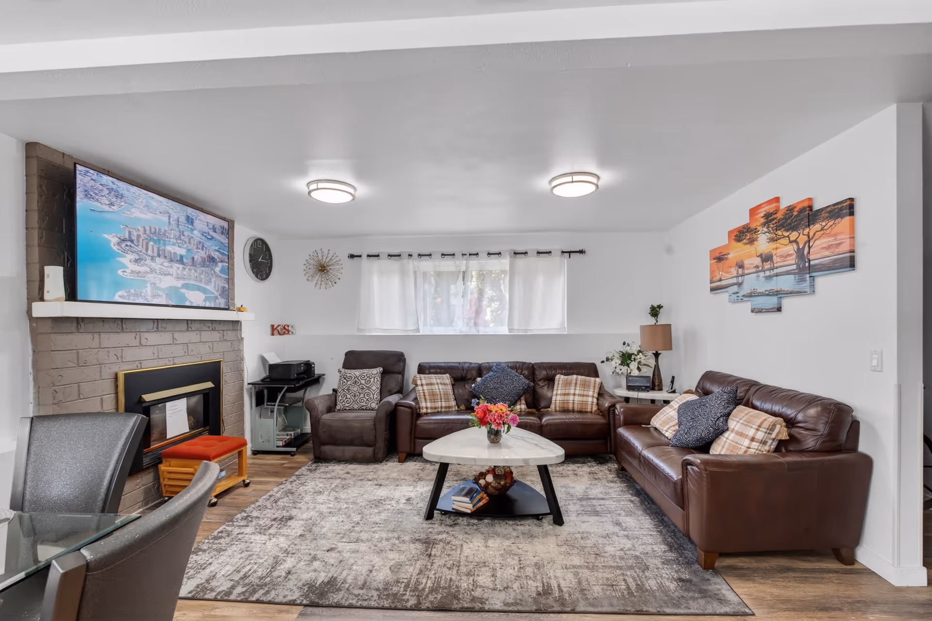 Cozy living room with brown leather sofas, coffee table, rug, and fireplace.