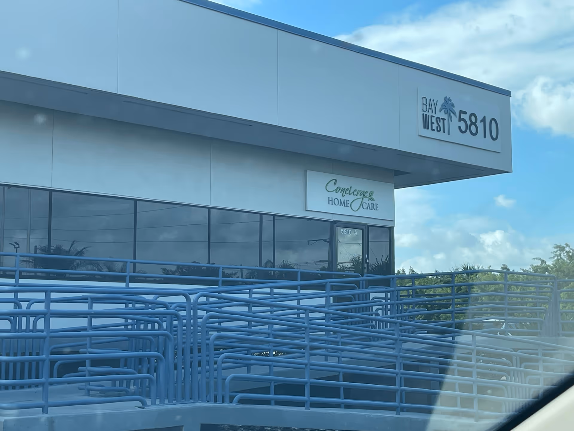 Exterior view of a modern building with Concierge Home Care sign and blue railing.