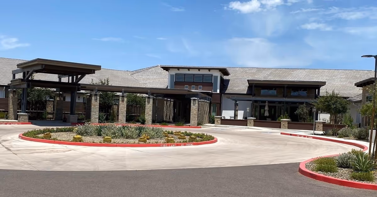 Exterior view of a Senior Care AZ building with circular driveway and landscaping.