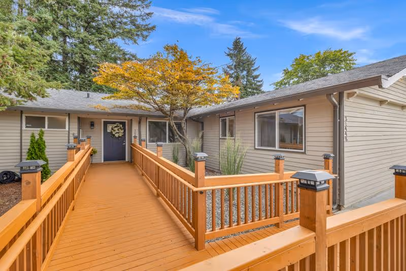 Single-story senior living building with a wooden ramp leading to a front entrance.