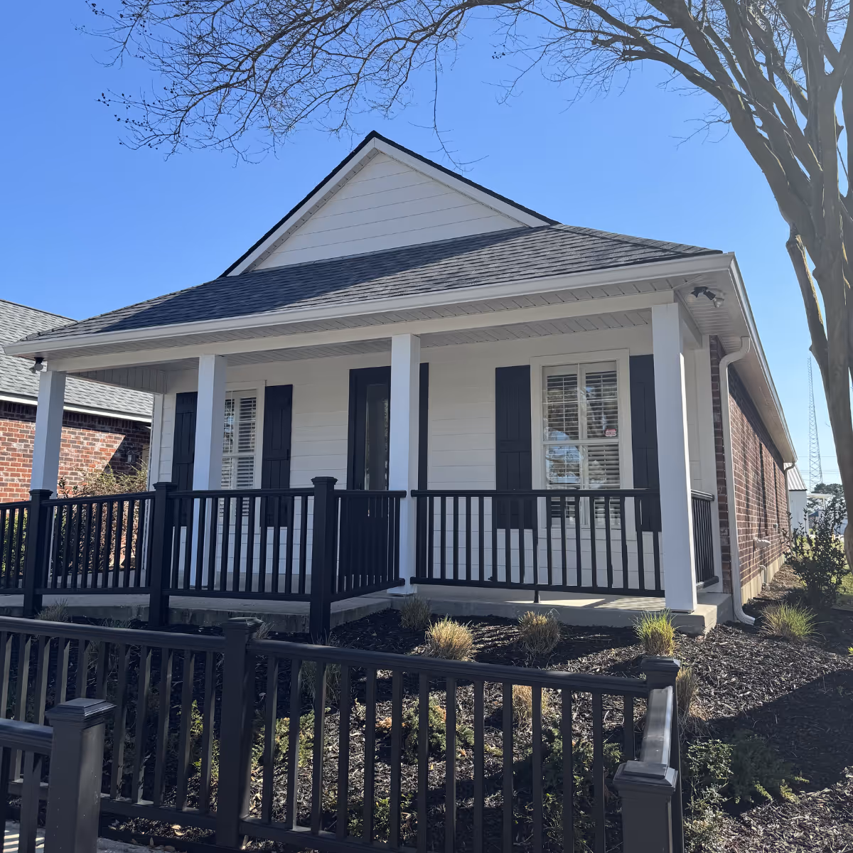 White single-story house with black shutters and a covered front porch.