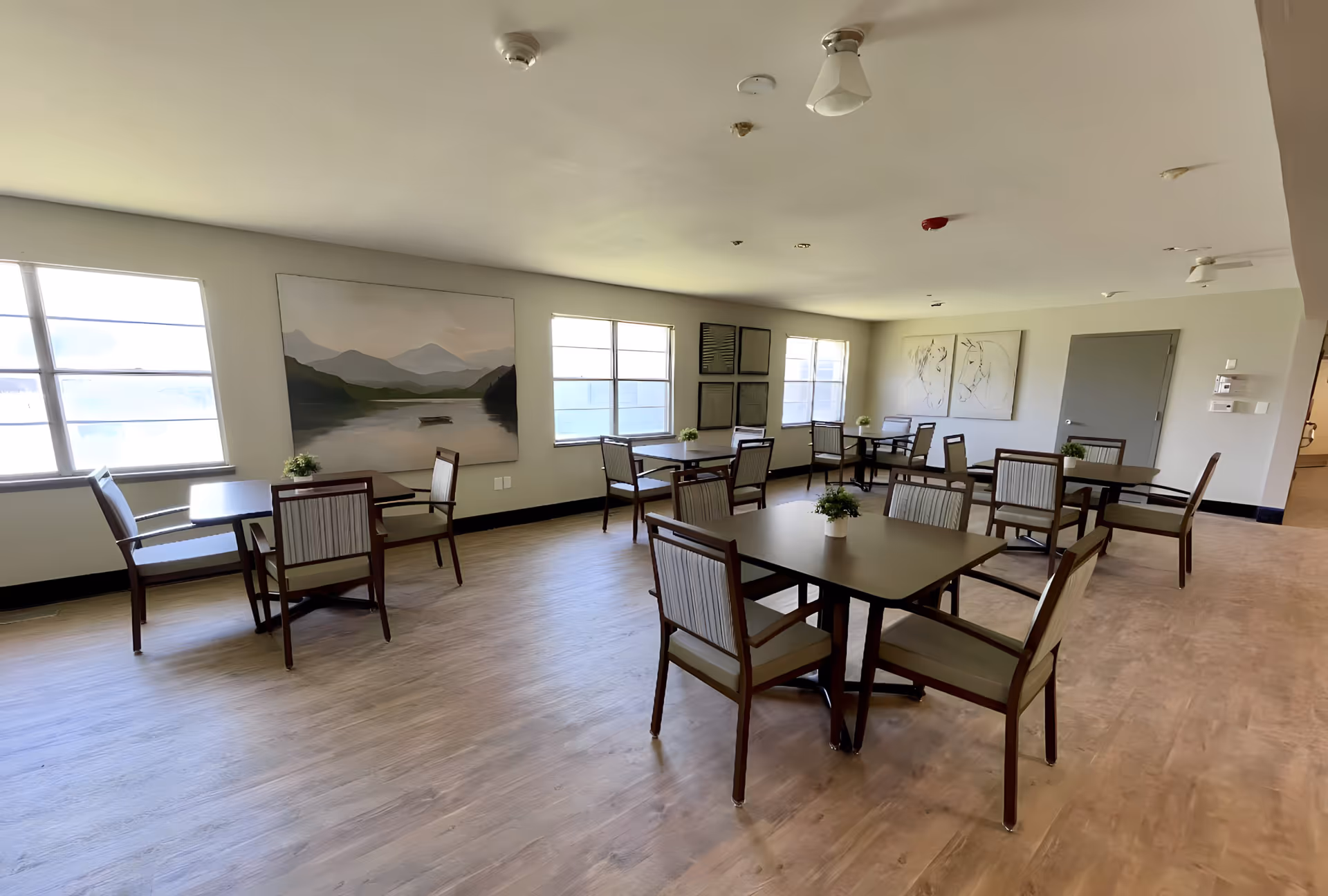 Interior dining area in Senior Village Nursing Home with multiple tables and chairs.