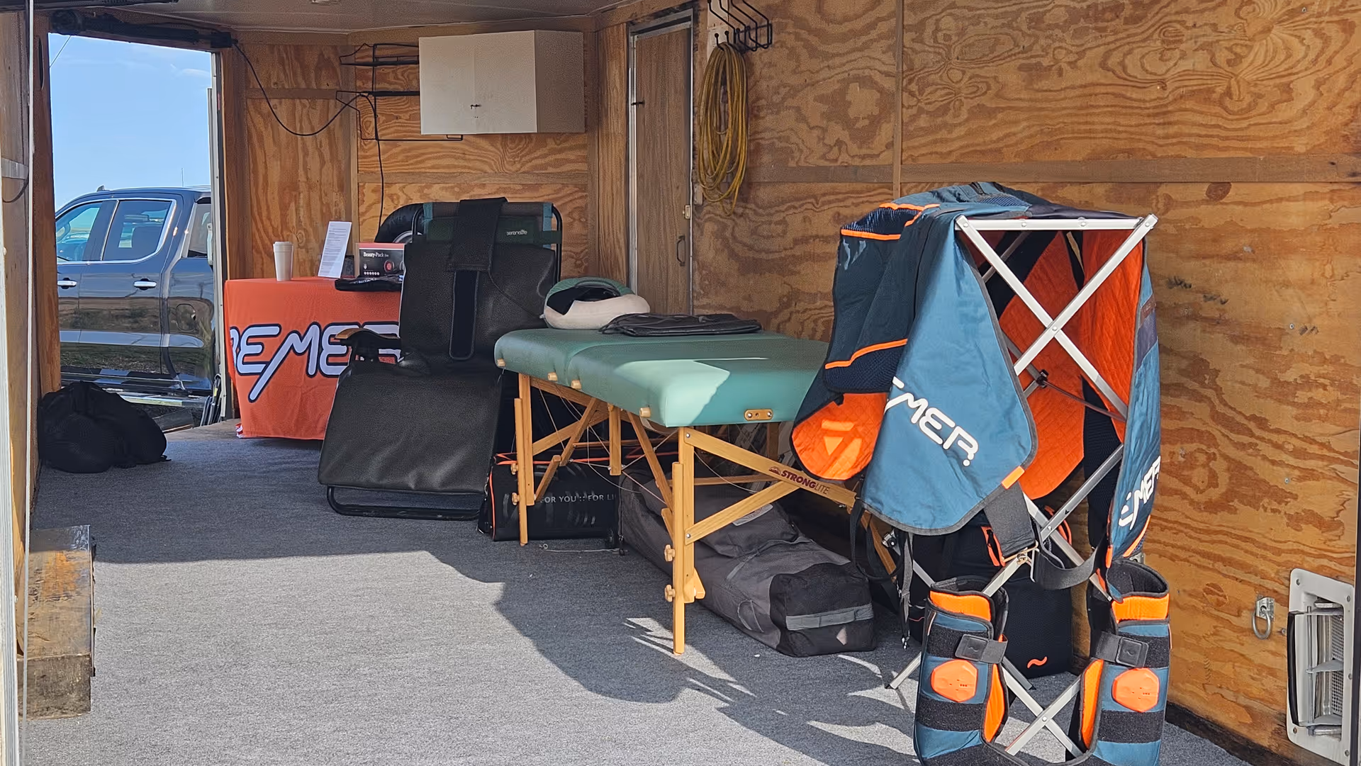 Interior trailer with a green examination table and medical equipment.