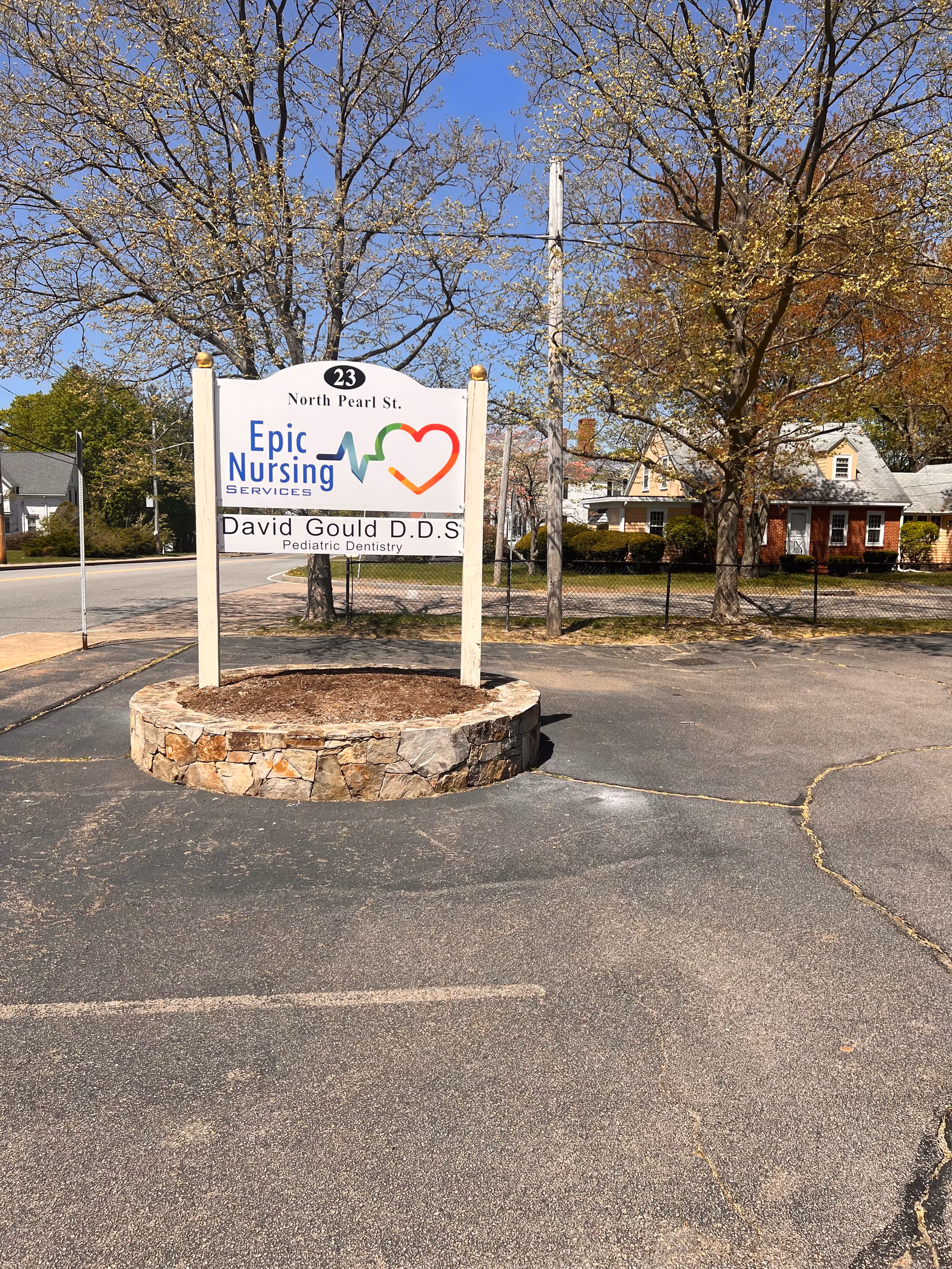 Outdoor sign for Epic Nursing Services LLC on a circular stone base in a parking area