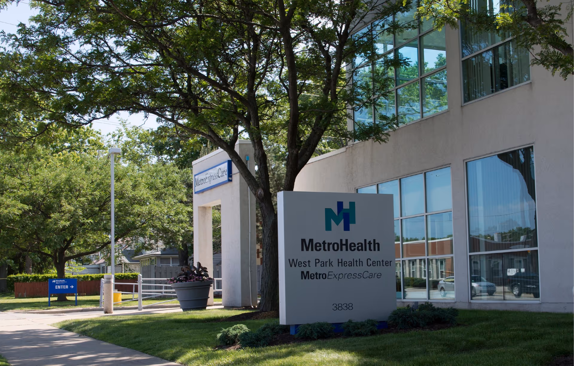 Exterior view of MetroHealth West Park Health Center with glass windows and a sign