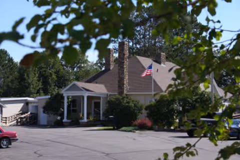 Exterior view of Nu-Roc Community Healthcare building with front entrance, flag, and trees.