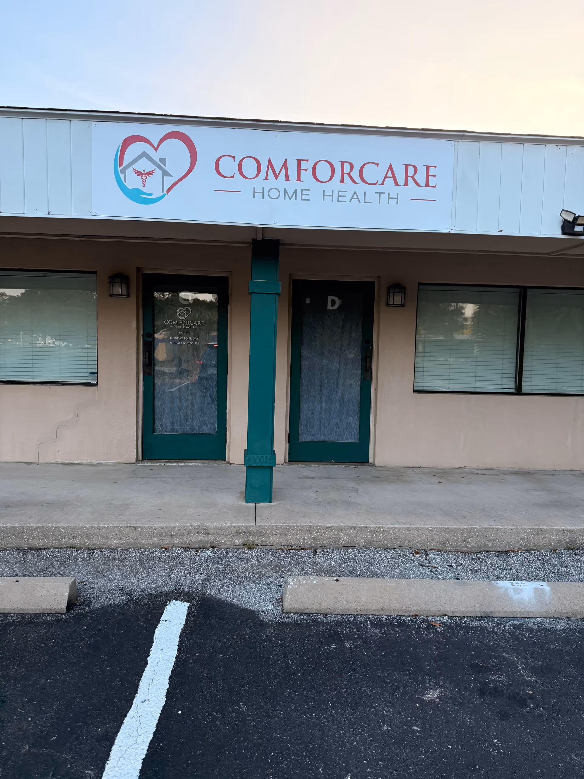 Exterior view of ComForCare Home Health storefront with two teal doors and sign.