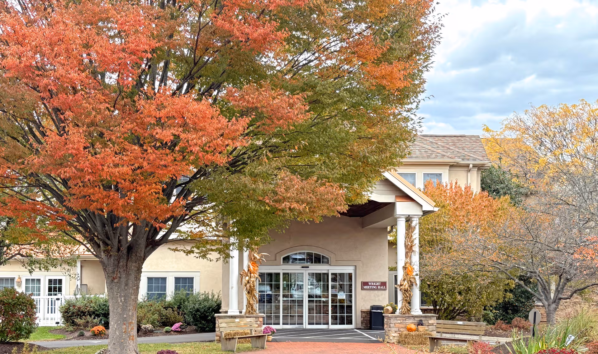 Entrance of Chandler Hall Health Services building framed by autumn trees.