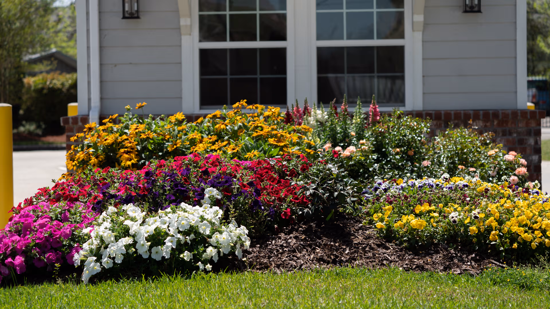 Exterior view of Christwood Retirement Community entrance with vibrant flower beds.