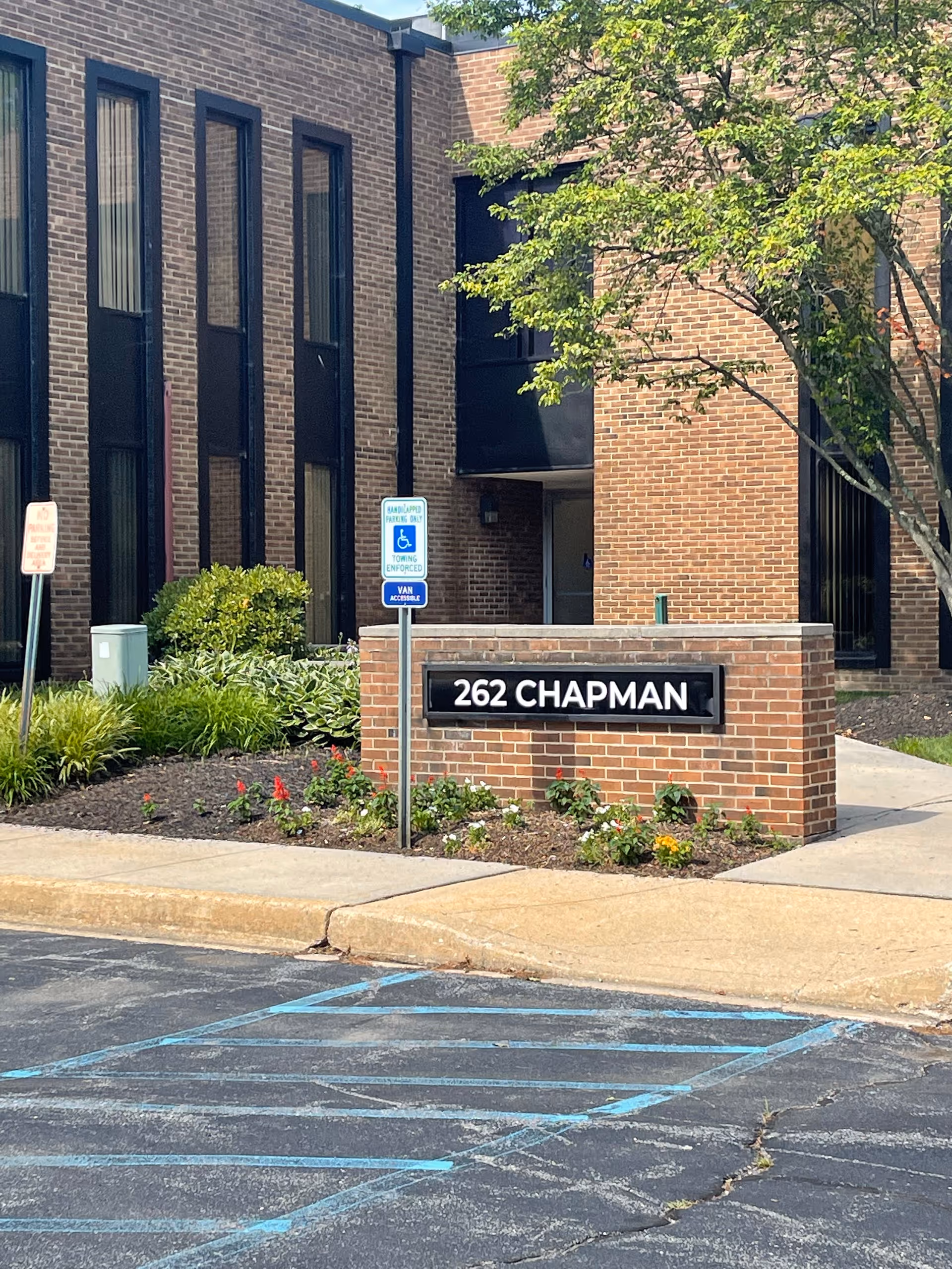 Brick facility exterior with 262 CHAPMAN sign and handicap parking sign nearby.