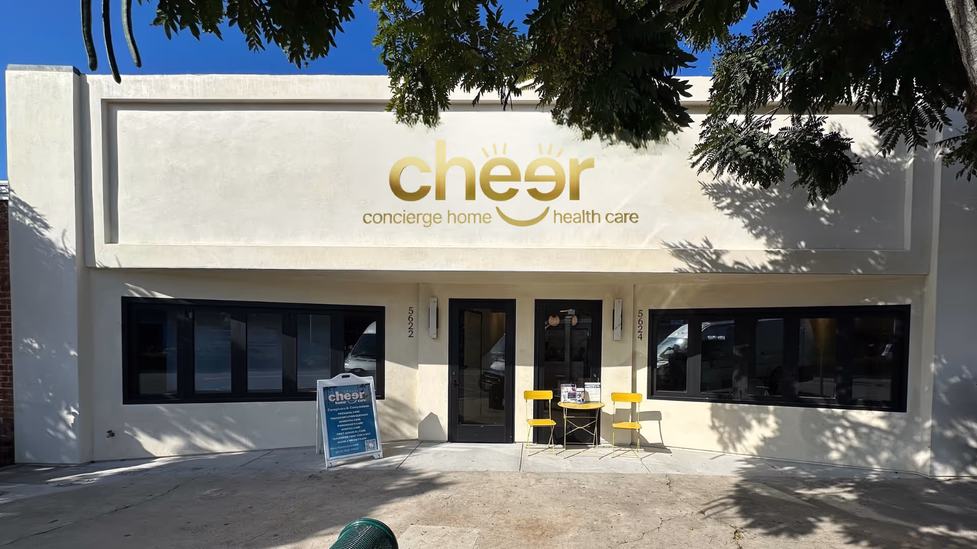 Exterior storefront of Cheer Home Care and Cheer Health Care with two yellow chairs outside.