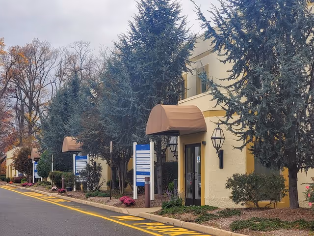 Exterior view of Home Helpers Home Care of Hamilton, NJ entrance with brown awnings and signs.