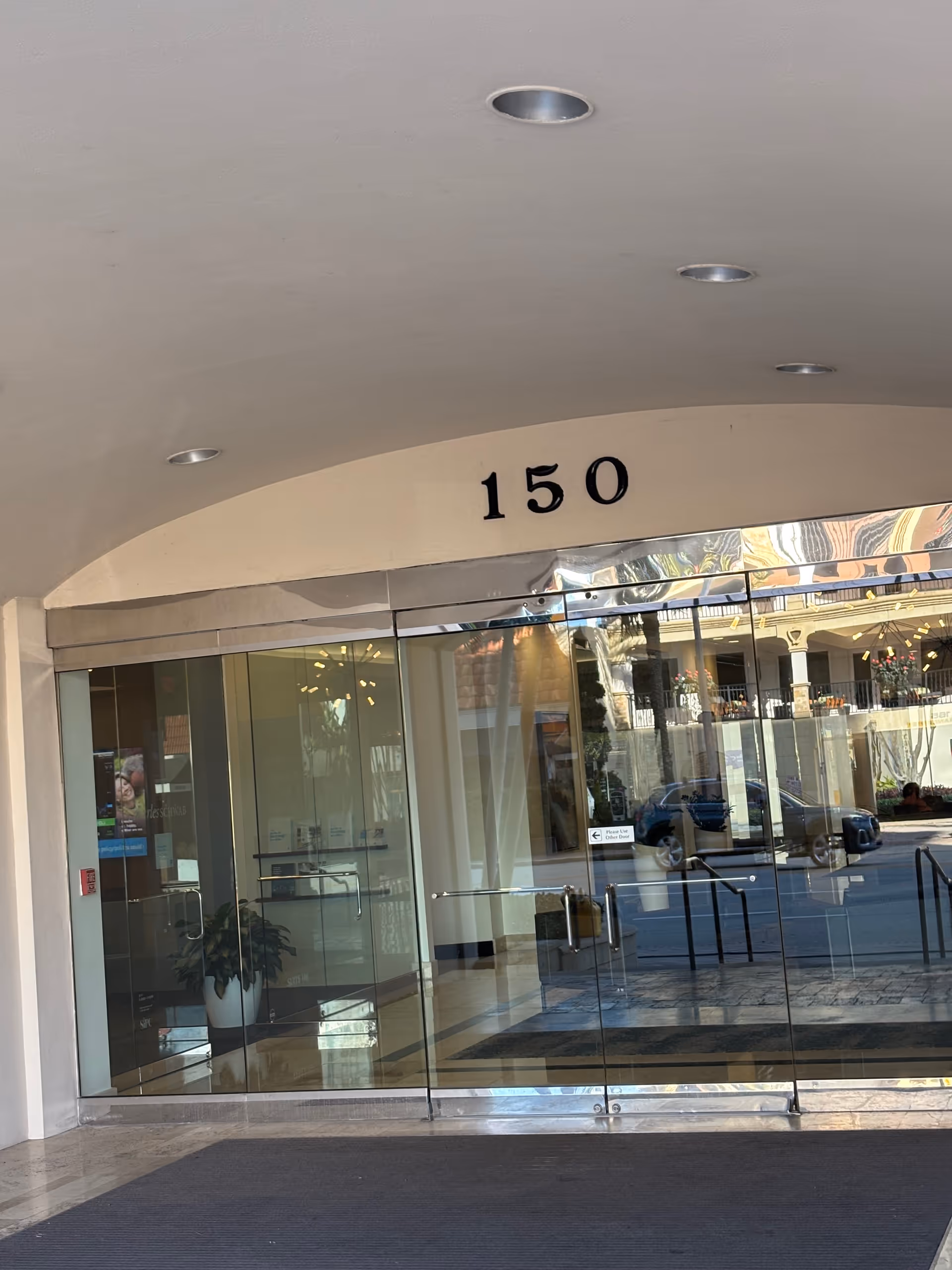 Glass entrance to a senior care building with arched canopy and 150.