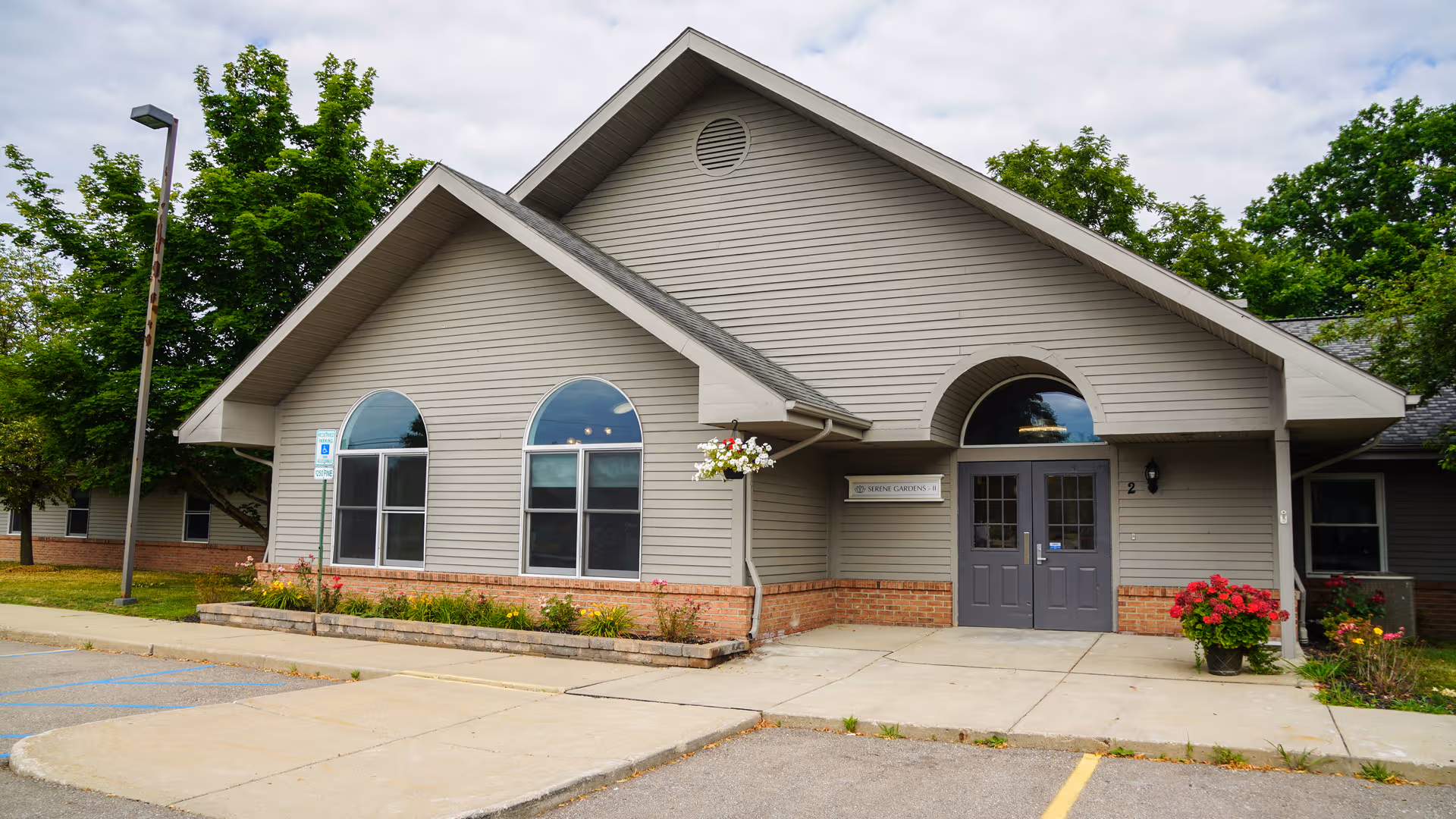 Front exterior of Serene Meadows of Grand Blanc, a senior living facility with arched windows.
