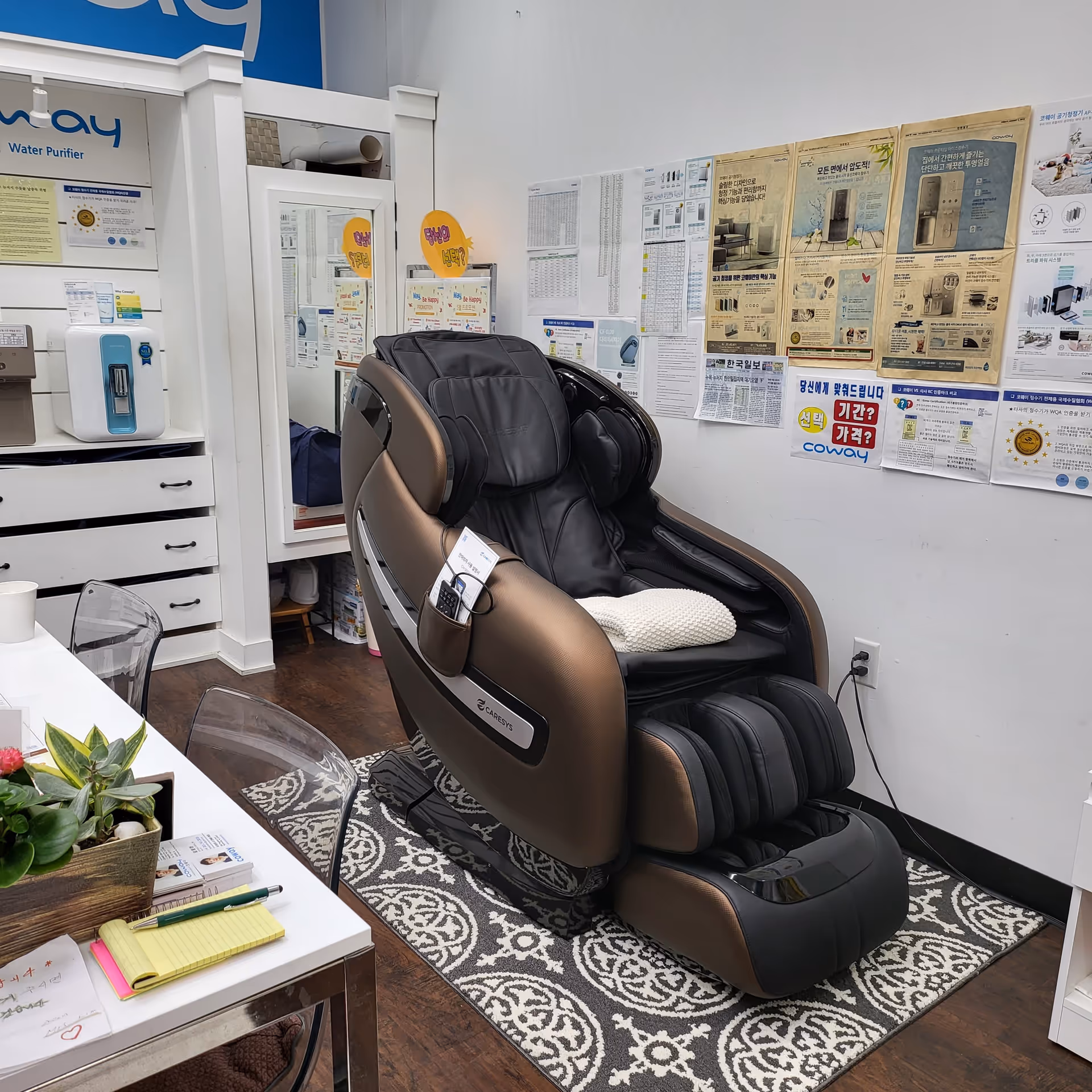 A large massage chair placed in a bright interior with posters on the wall.
