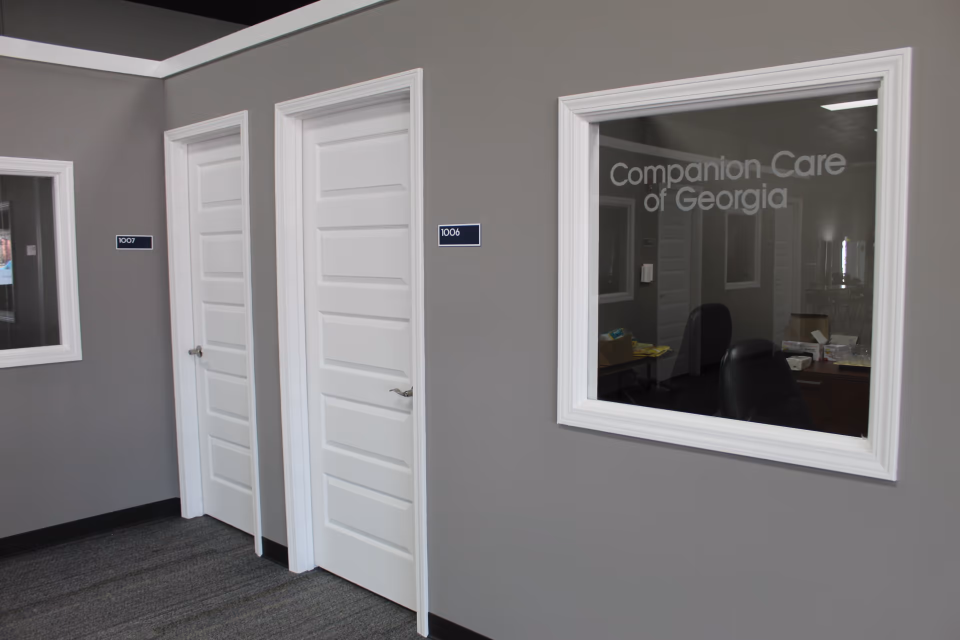 Grey hallway with white doors and a window showing Companion Care of Georgia signage