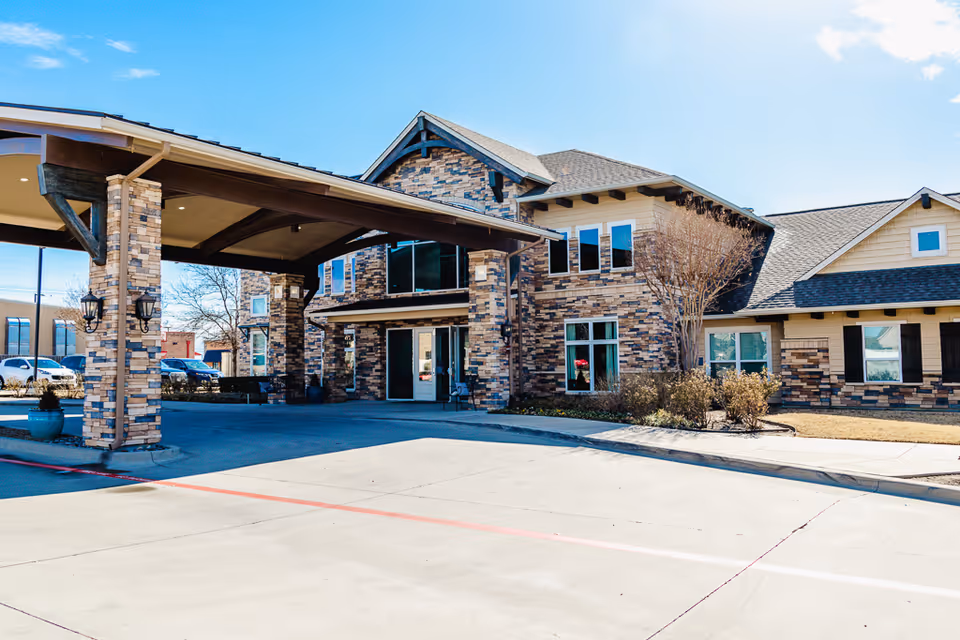 Stone-brick assisted living facility with a covered entrance and curved driveway.