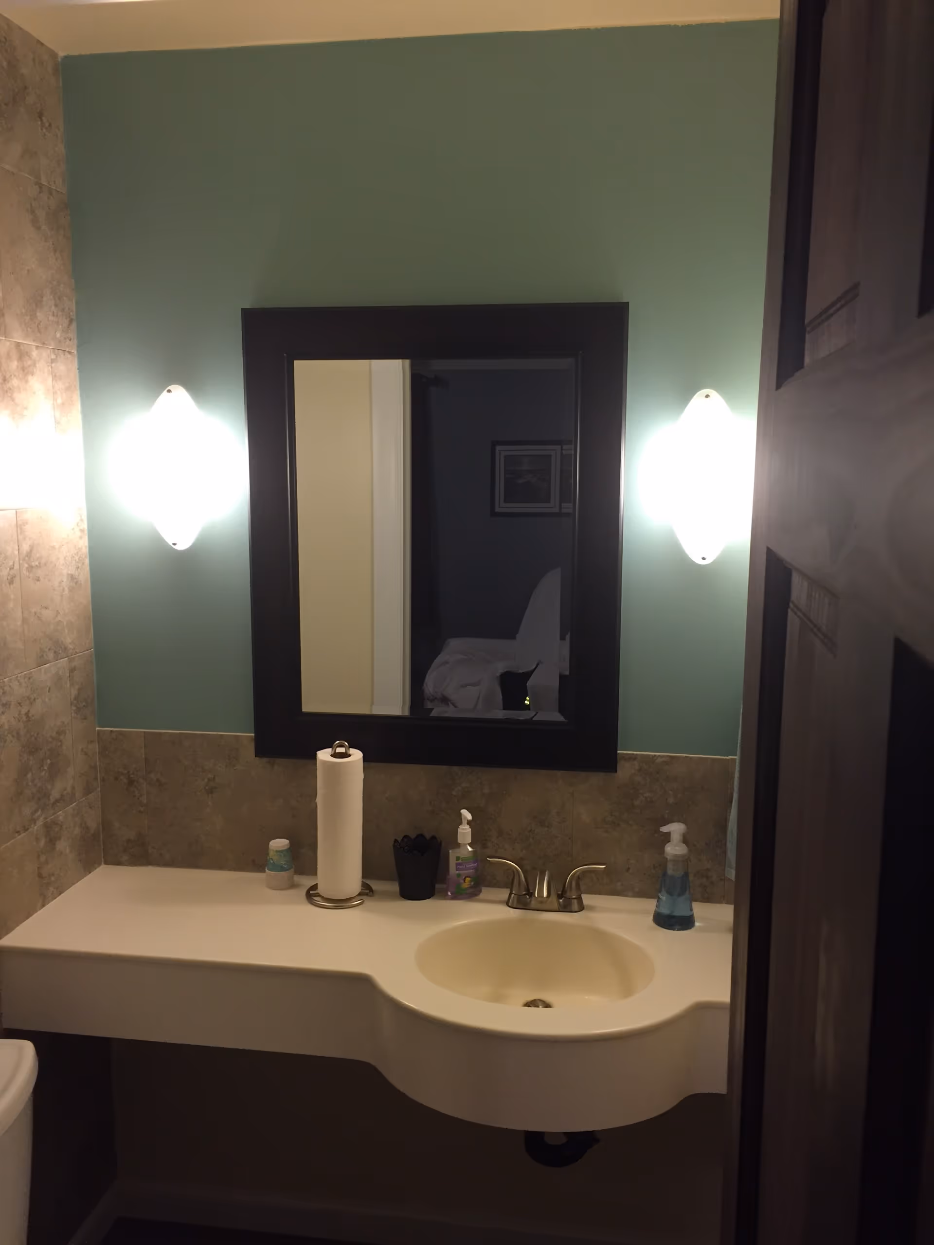 Bathroom vanity with sink, mirror, and two wall-mounted lights.