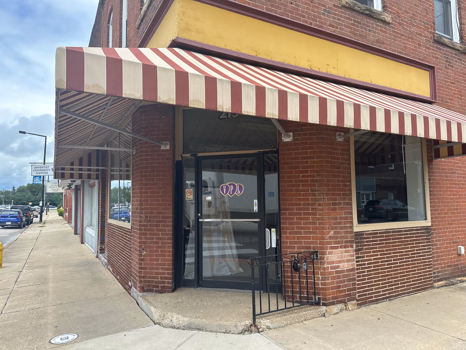 Brick storefront with striped awning and glass entrance, VPL Healthcare Solutions sign on door.