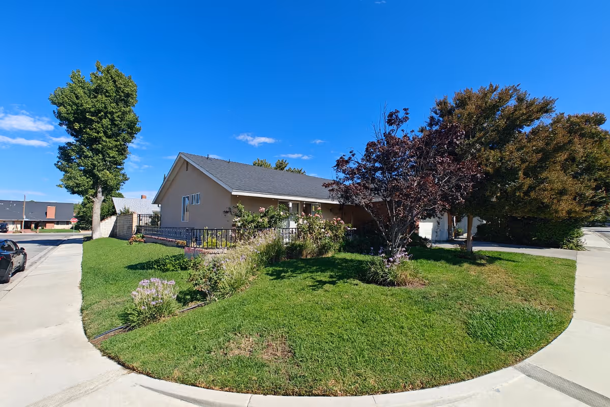 Exterior view of Affectionate Care Home: a single-story building with curved driveway and landscaped lawn.