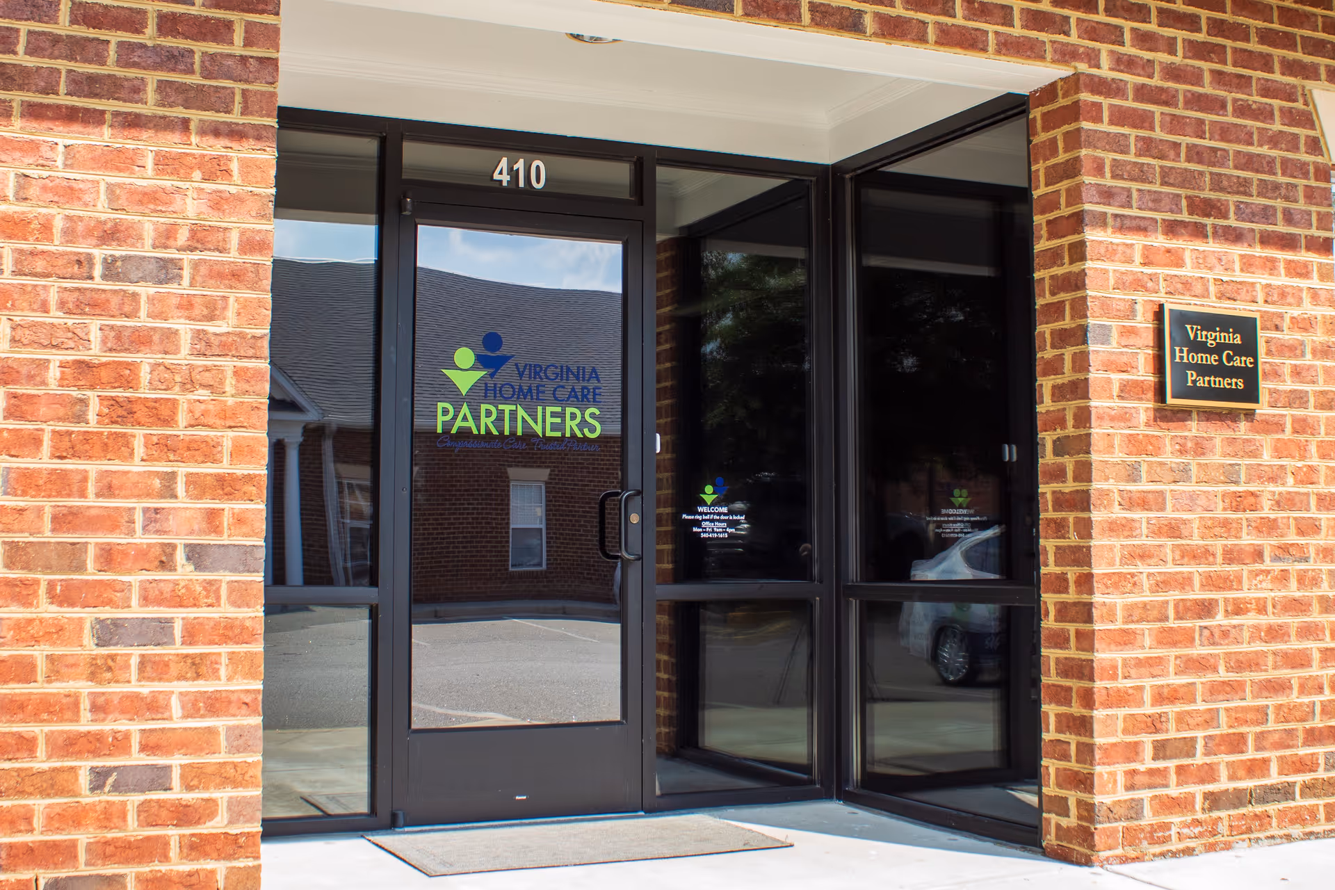 Brick building exterior with glass doors displaying Virginia Home Care Partners logo and 410.