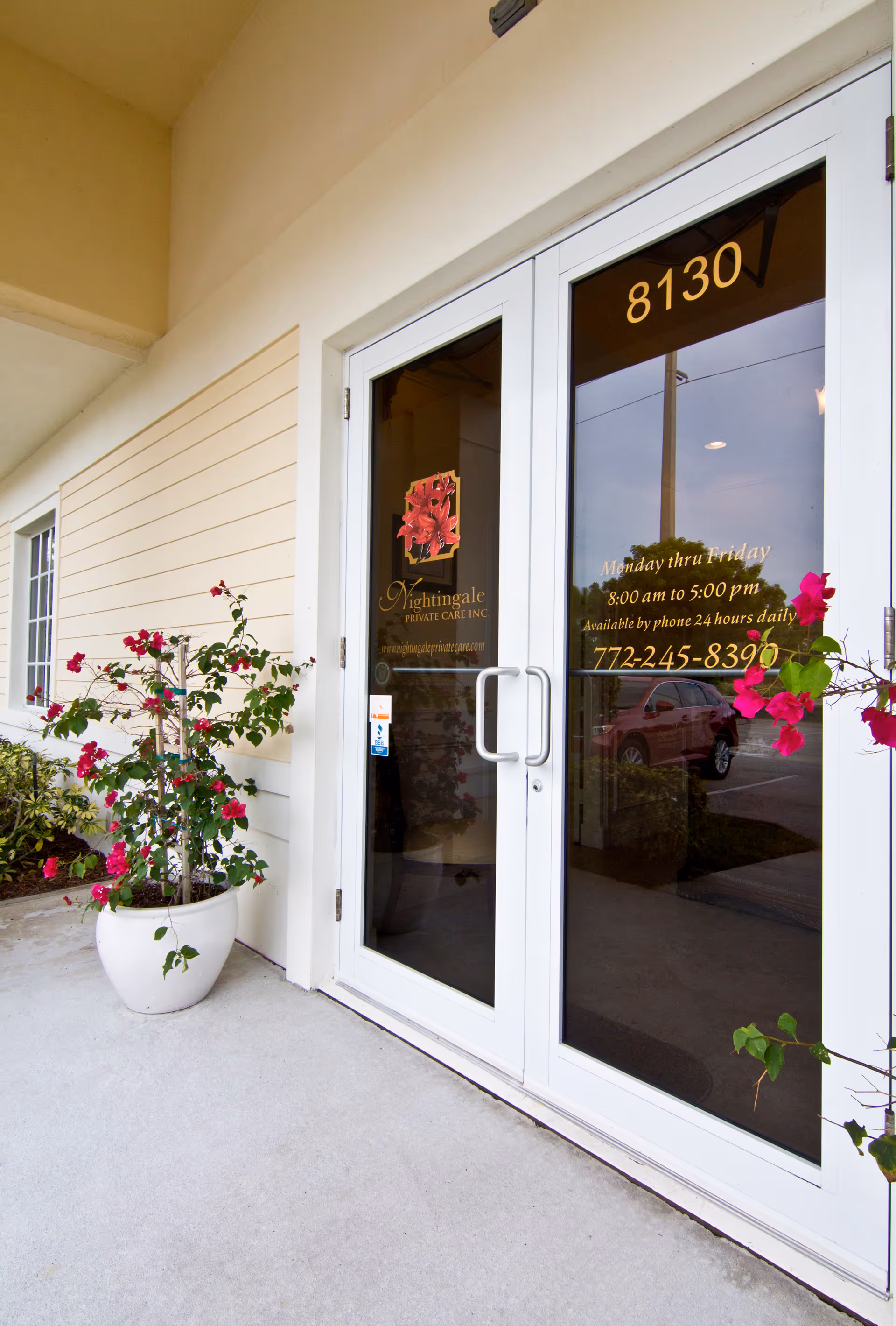 Double glass doors with Nightingale Private Care signage and potted roses outside the entrance.